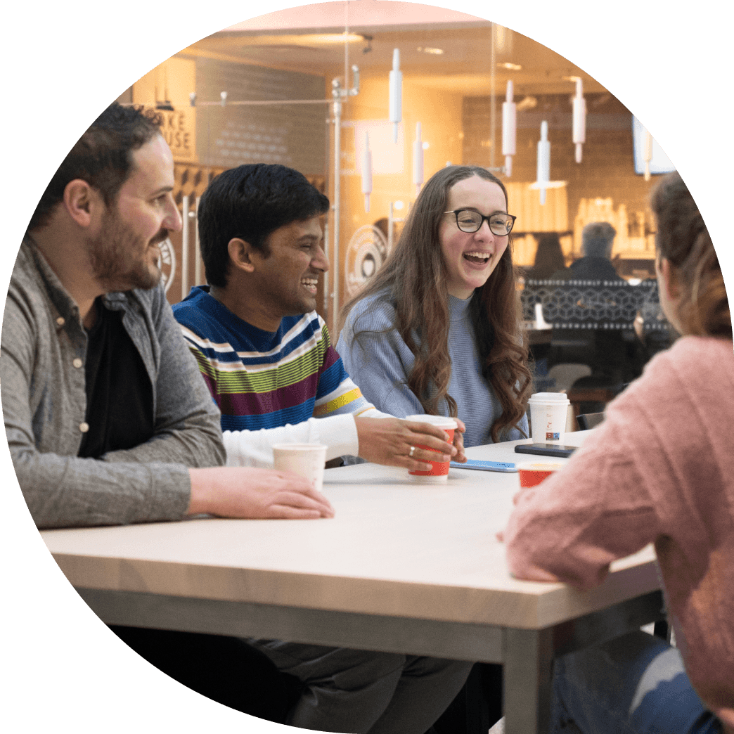 Members of the Fire team gathered around a table in a café, engaged in a lively conversation.